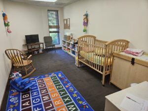 image of nursery. image includes crib, changing table, rocking chair and shelf of toys